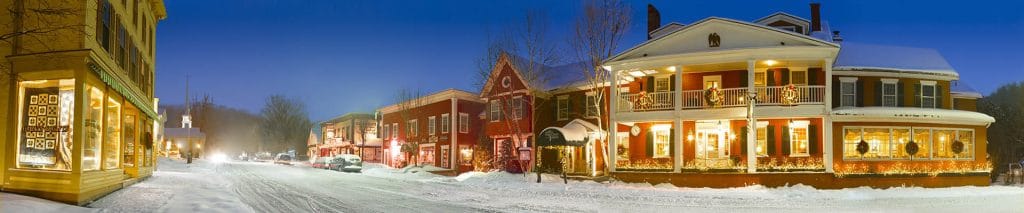 A quiet downtown corner at night, covered in snow with lights glowing