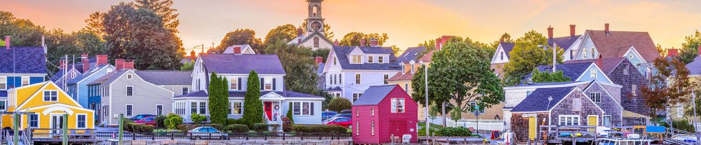 A small New England harbor town, viewed from the water at sunrise